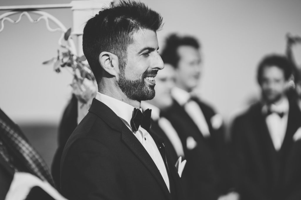 groom smiles while seeing bride walk down the aisle