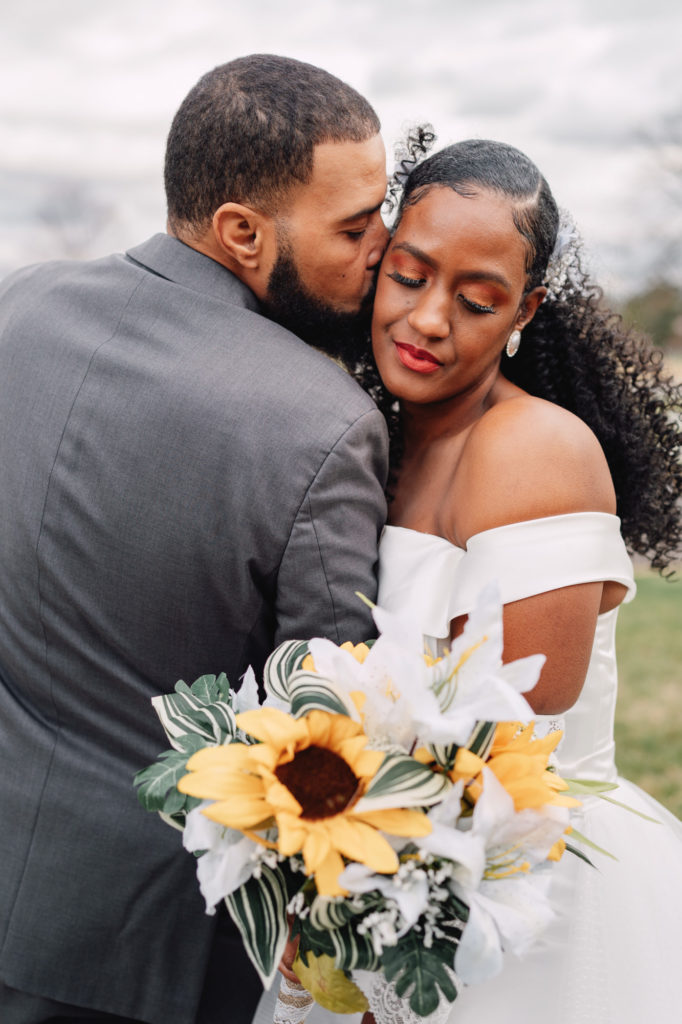 groom kissing bride on cheek during portrait session at Northern Virginia wedding