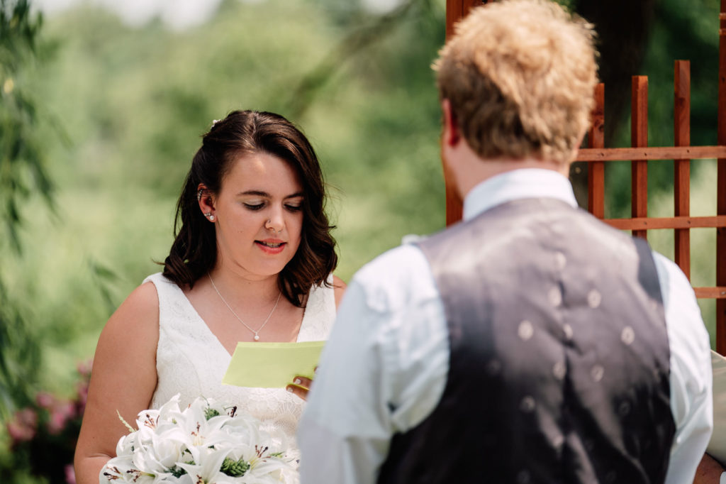 bride reading personalized vows to groom during their wedding ceremony