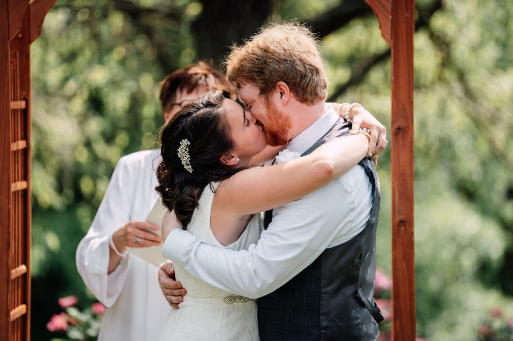 bride and groom share their first kiss during their wedding ceremony