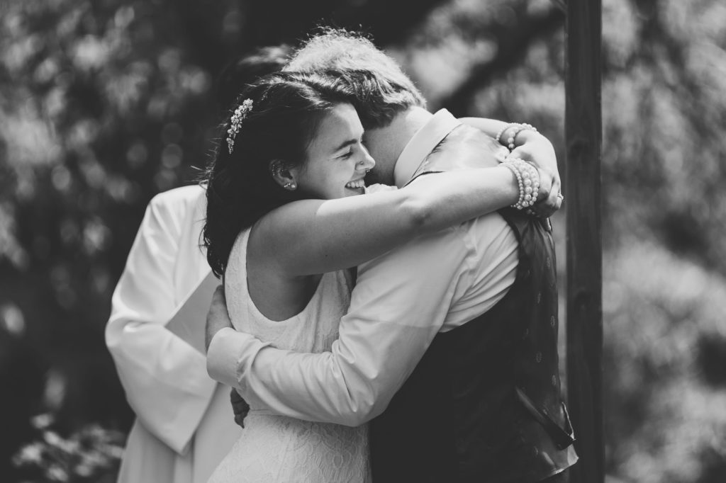 bride and groom hug after their first kiss 