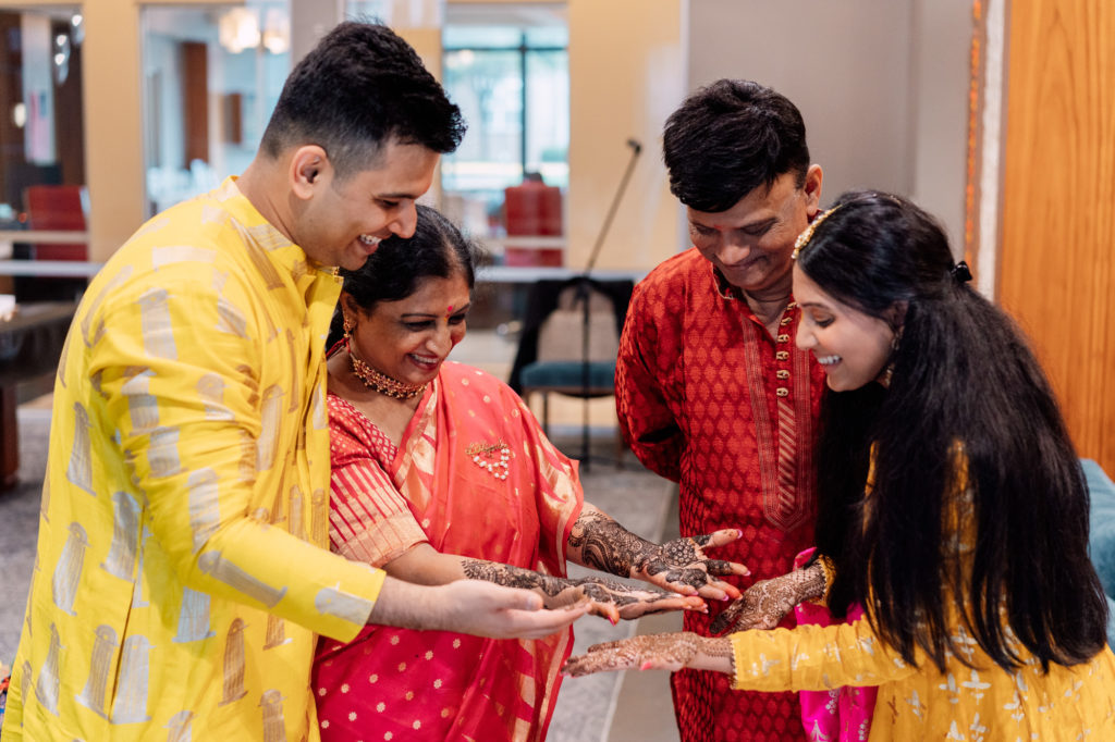 bride and groom display their mehndi designs to their parents