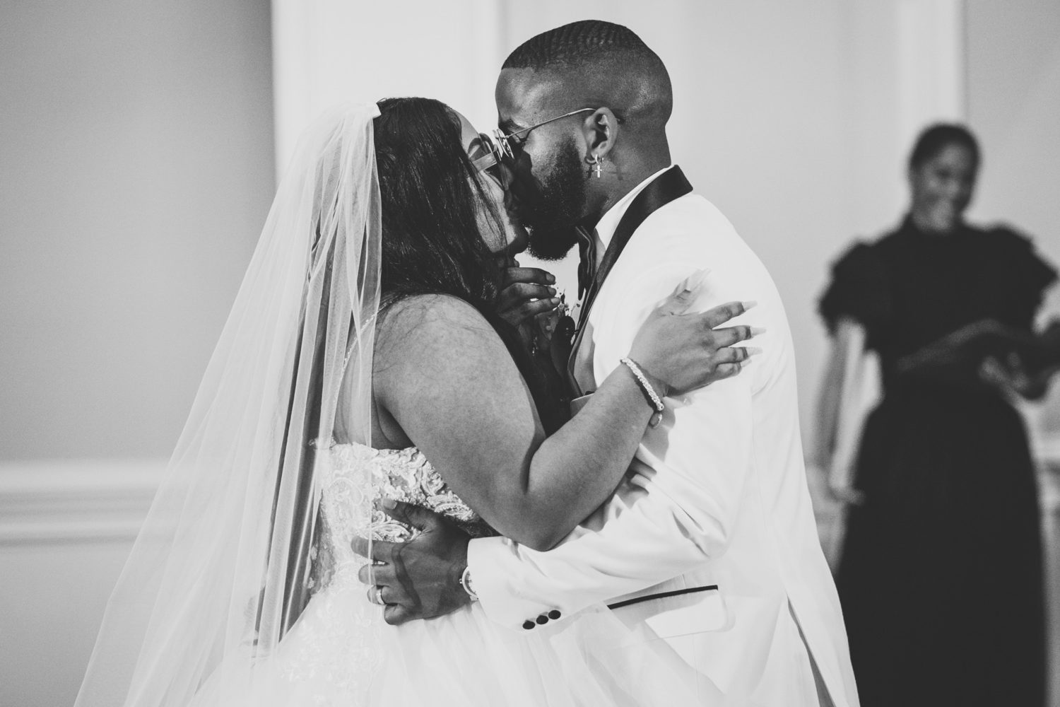 bride and groom share their first kiss in front of family and friends