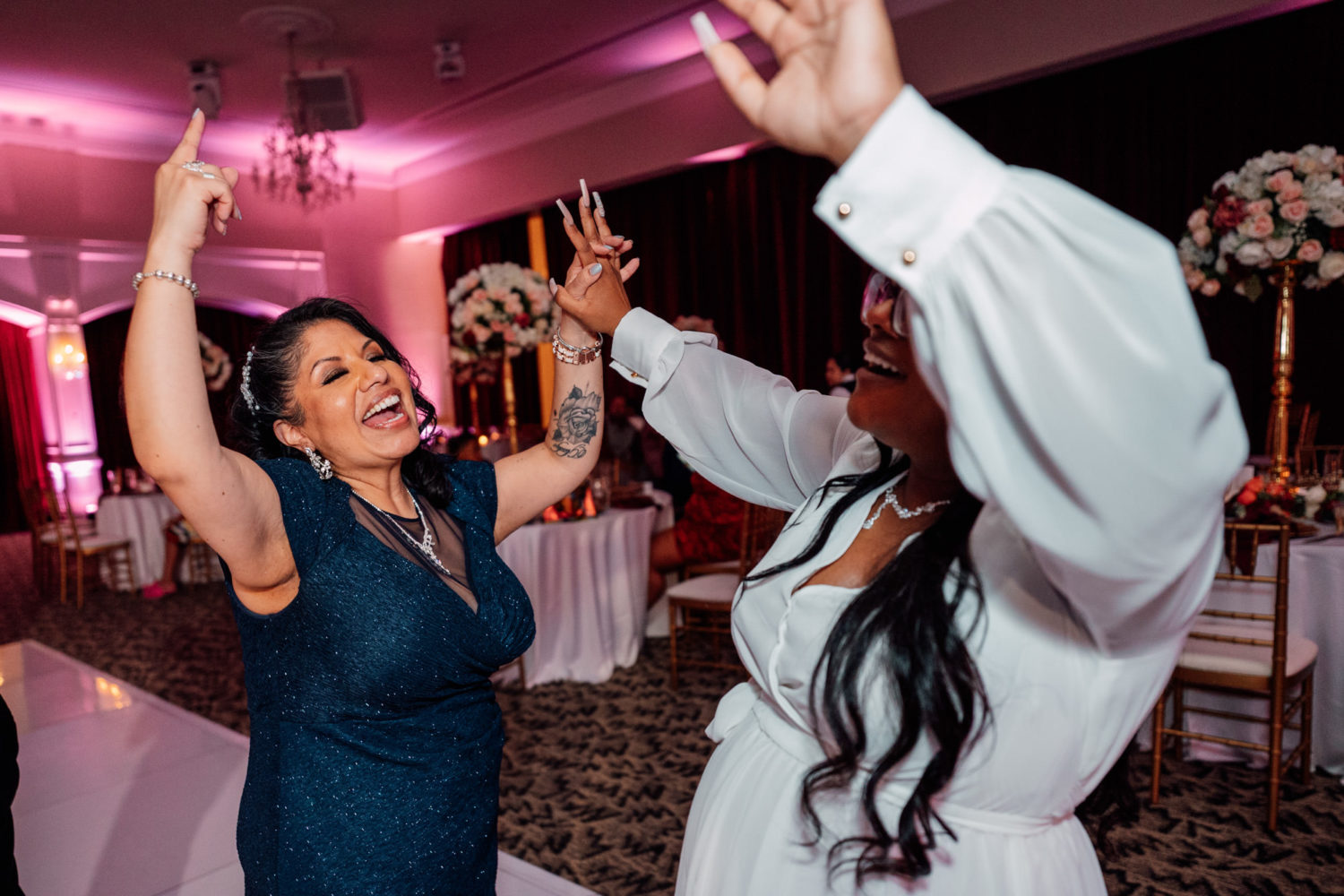 bride dancing with her mother while having fun at her wedding reception