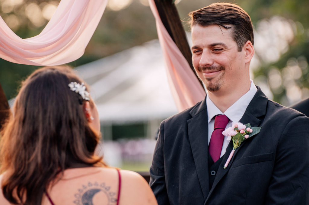 groom looking at bride and smiling during their wedding ceremony