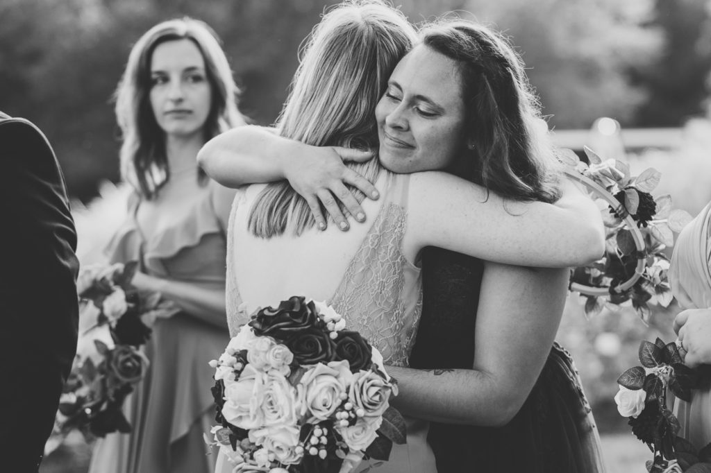 bride hugs bridesmaid after the wedding ceremony concluded