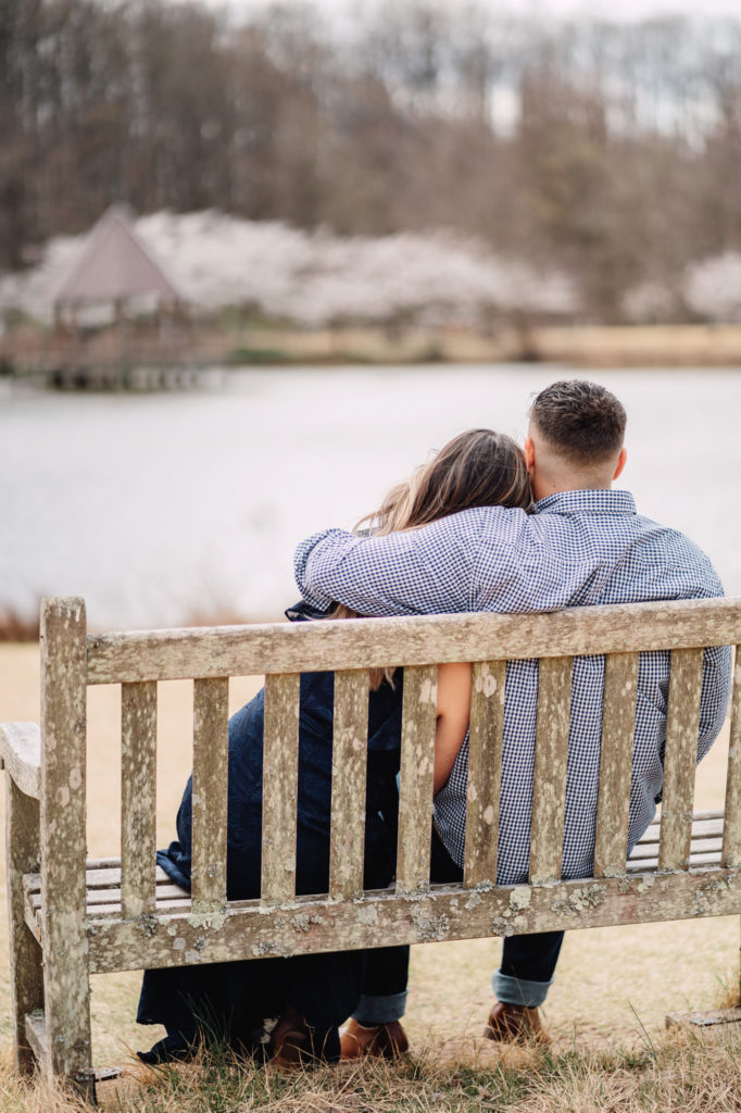 couple cuddling while together on a bench