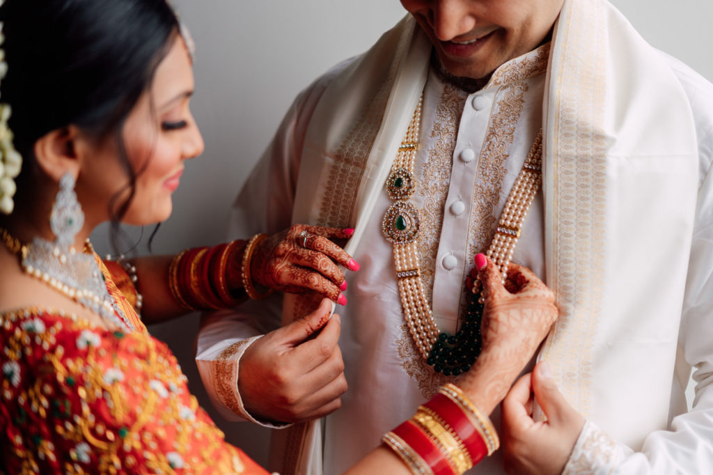indian bride helping groom get ready