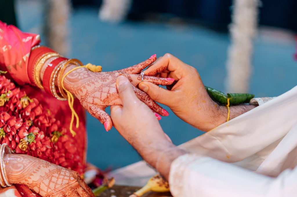 groom putting ring on bride during indian wedding at a Maryland wedding
