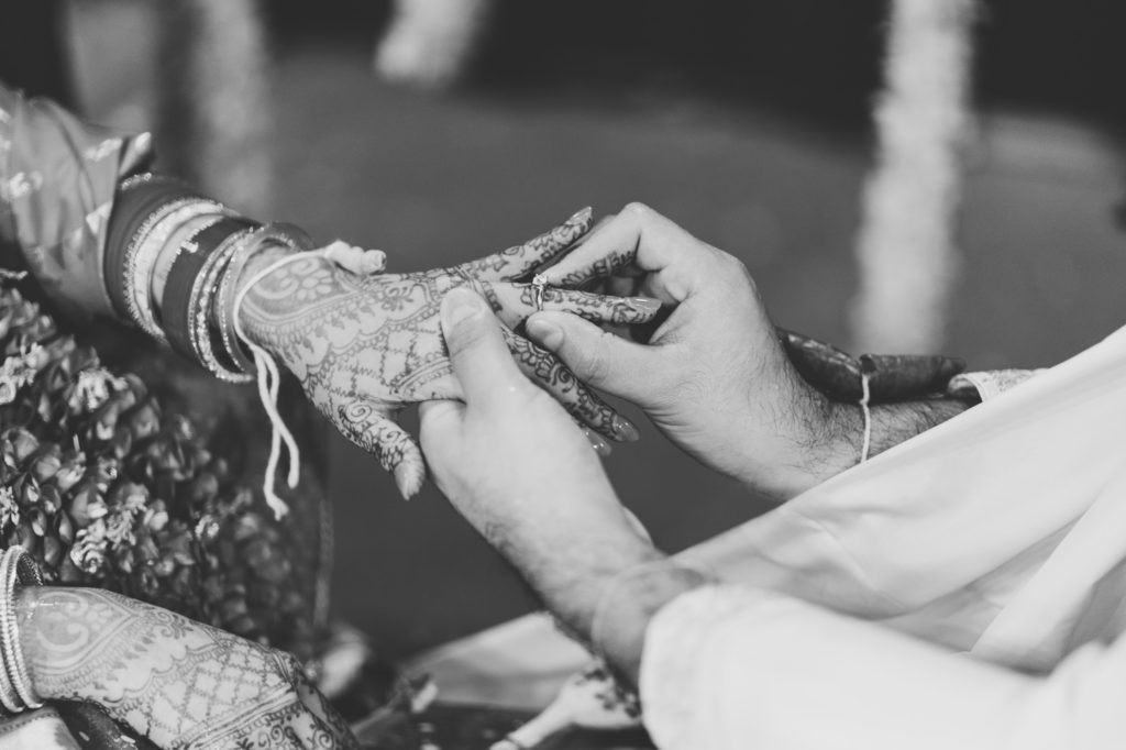 groom placing ring on bride's hand