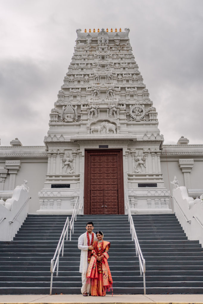bride and groom in front of the sri siva vishnu temple