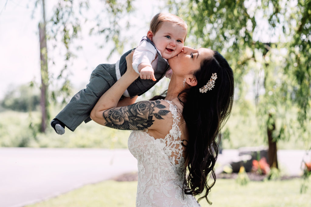 bride hugging baby and smiling 