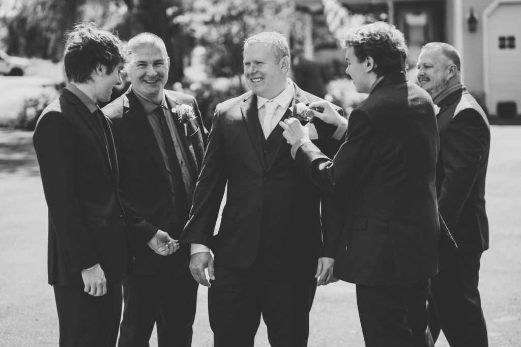 groom getting ready with his groomsmen before wedding ceremony