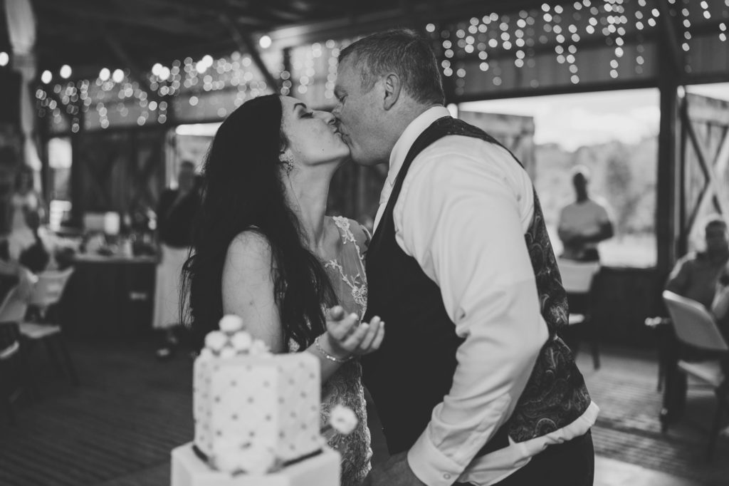 bride and groom kissing after cutting cake at maryland wedding