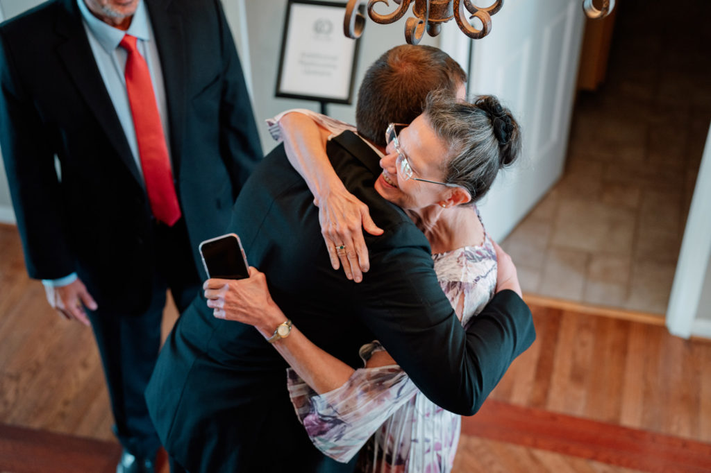 groom hugging his mother before wedding ceremony begins
