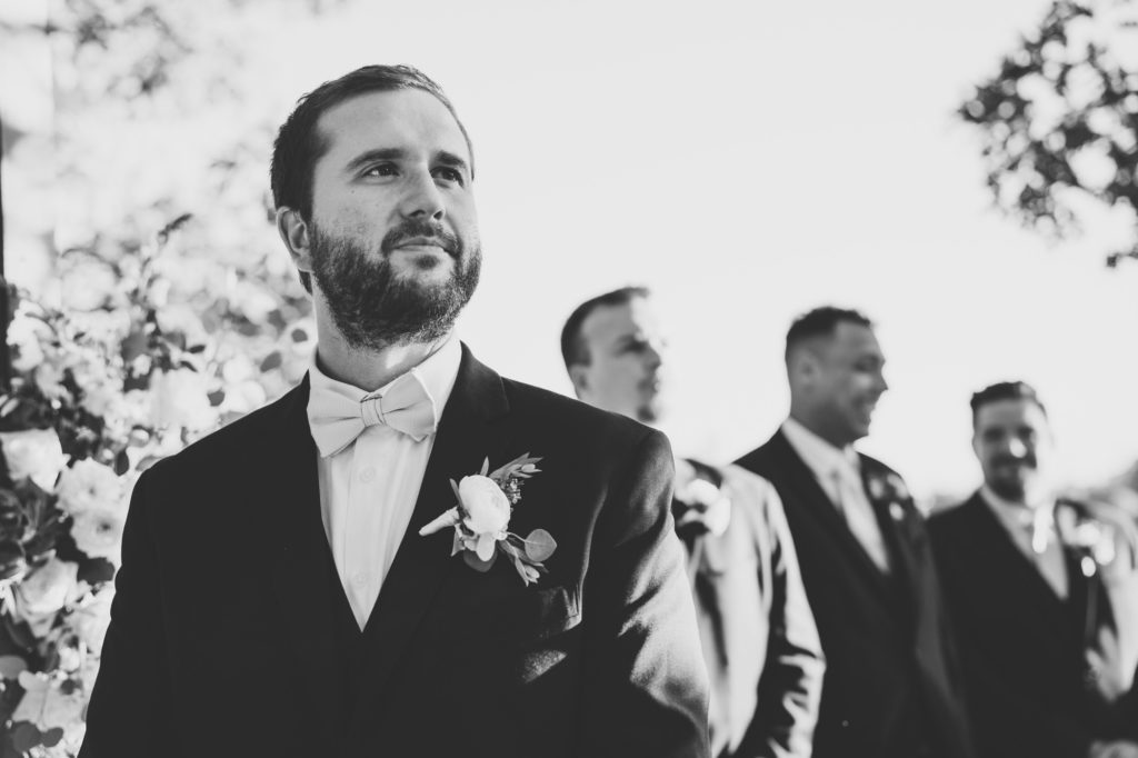 groom stoic reaction to seeing bride walking down the aisle
