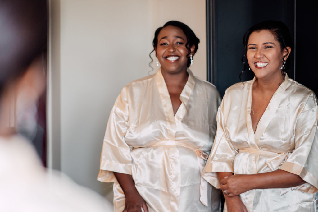 bridesmaids smiling and having fun with their robes on