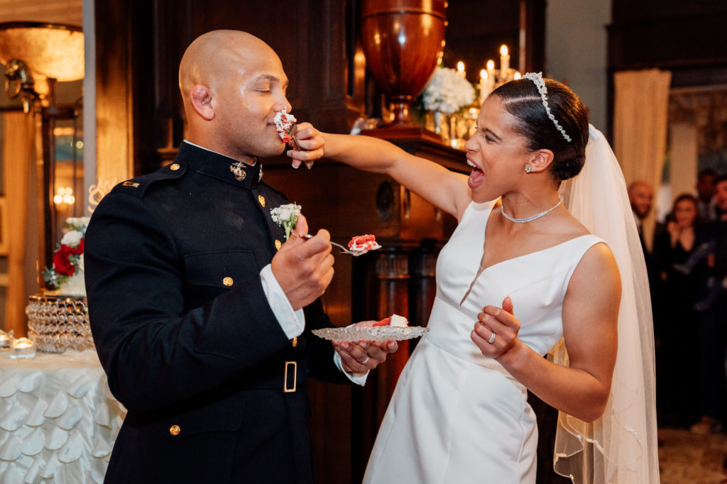 bride smashing cake in grooms face during cake cutting at wedding reception