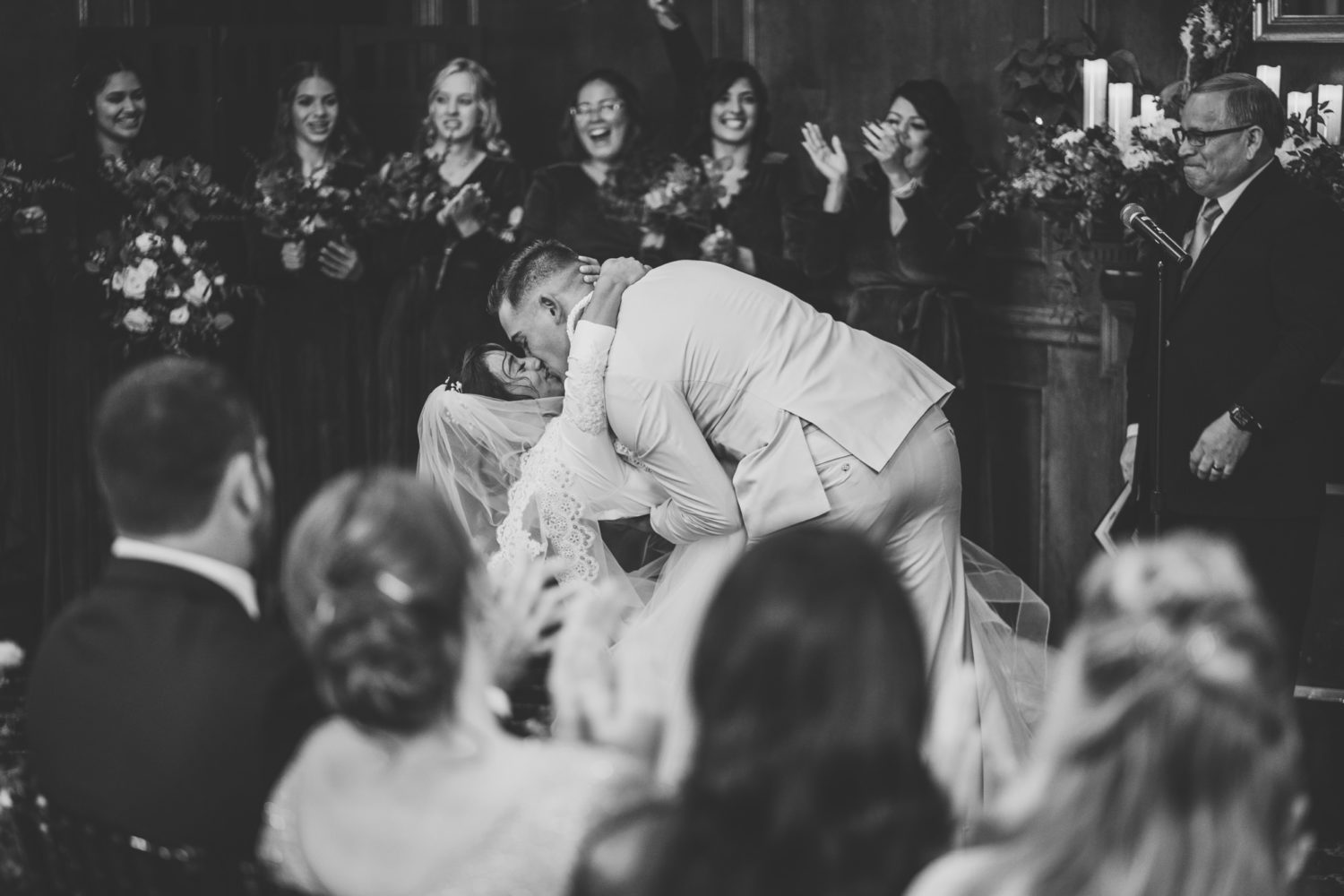 bride and groom celebrating and sharing their first kiss in front of guests