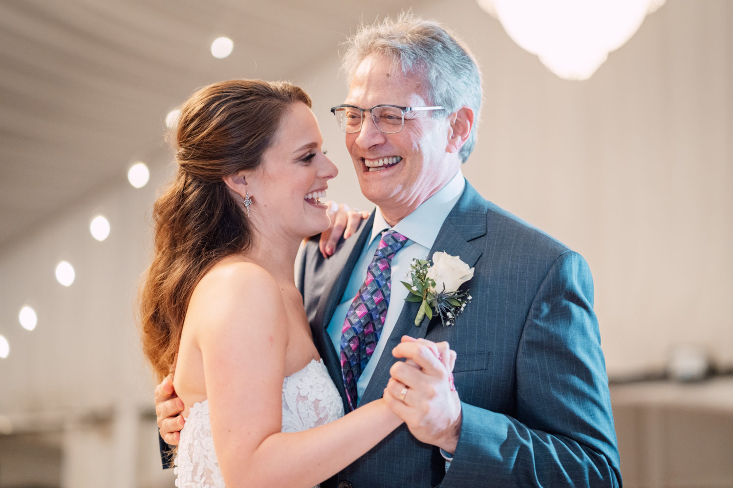 bride and father sharing their first dance and laughing together