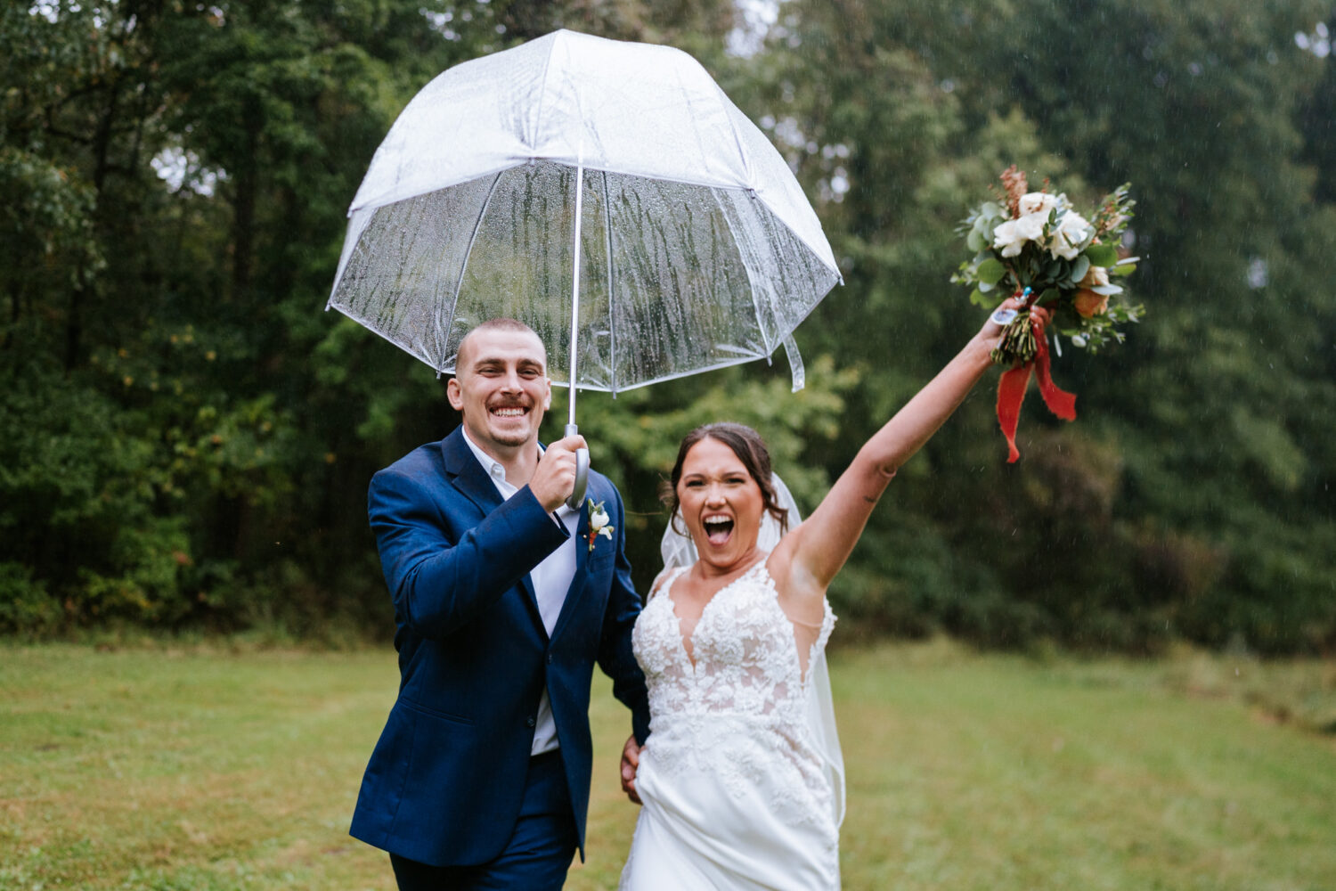 bride and groom running in the rain together on their wedding day