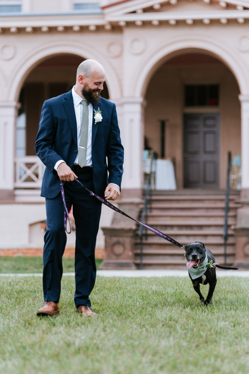 groom walking down the aisle with his pet dog
