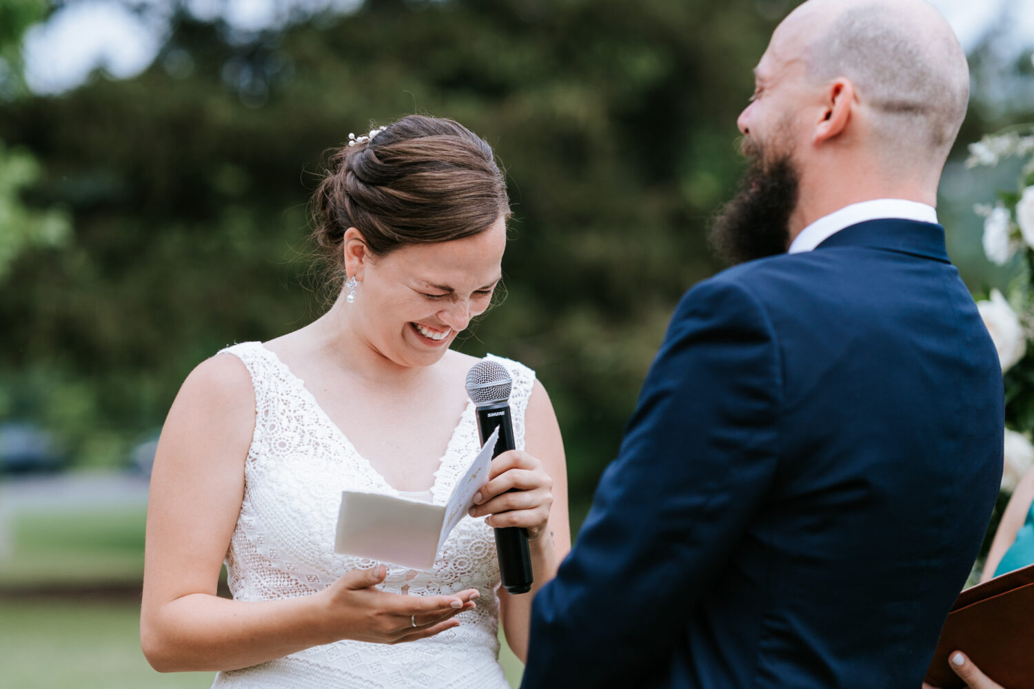 bride laughing while make reading her vows