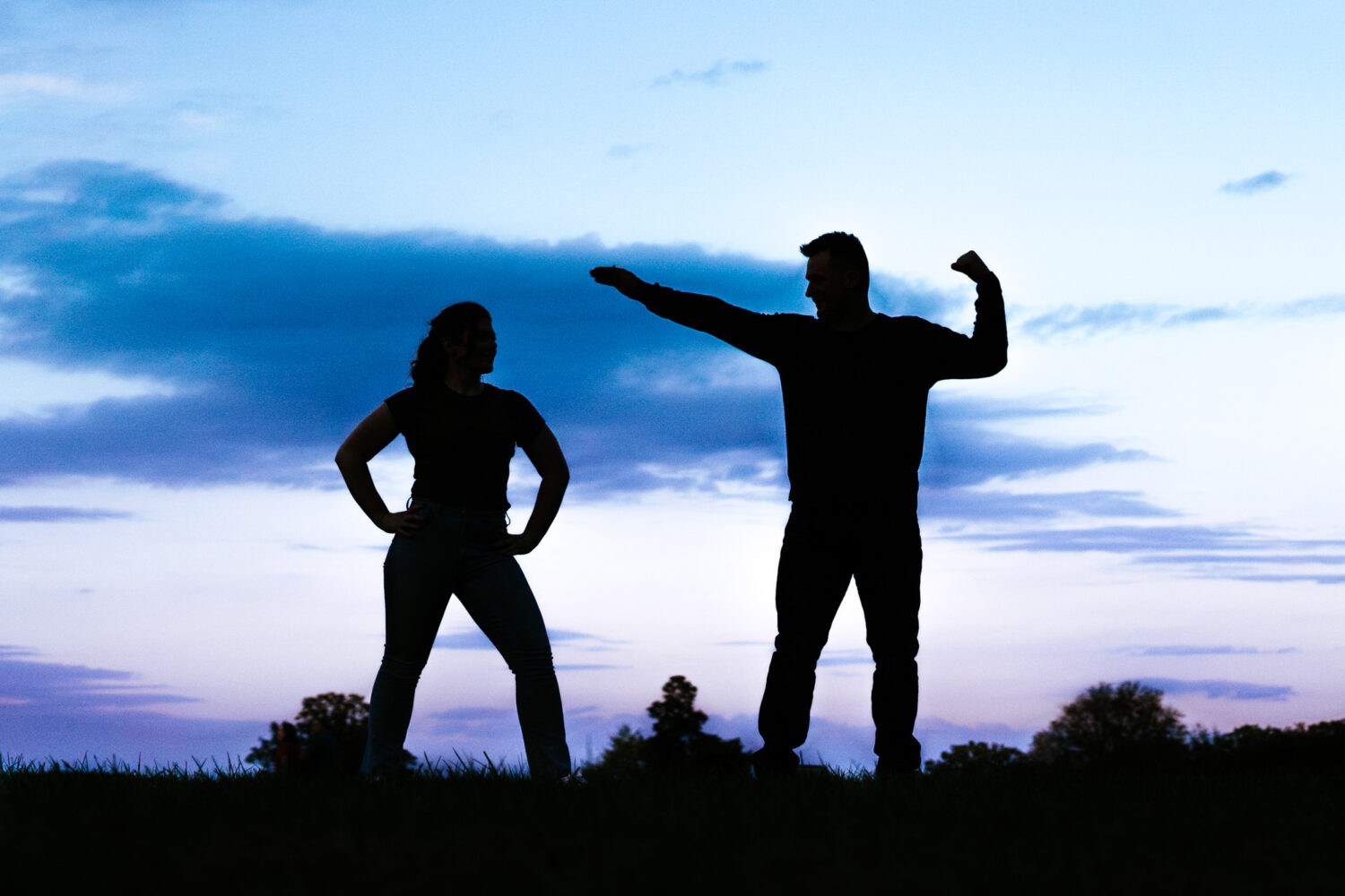 couple posing for an epic silhouette image during blue hour