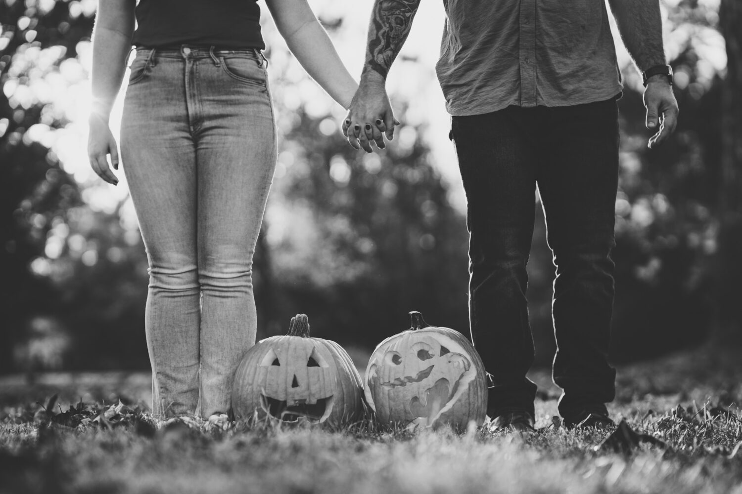 bride and groom holding hands while showing off their carved halloween pumpkins