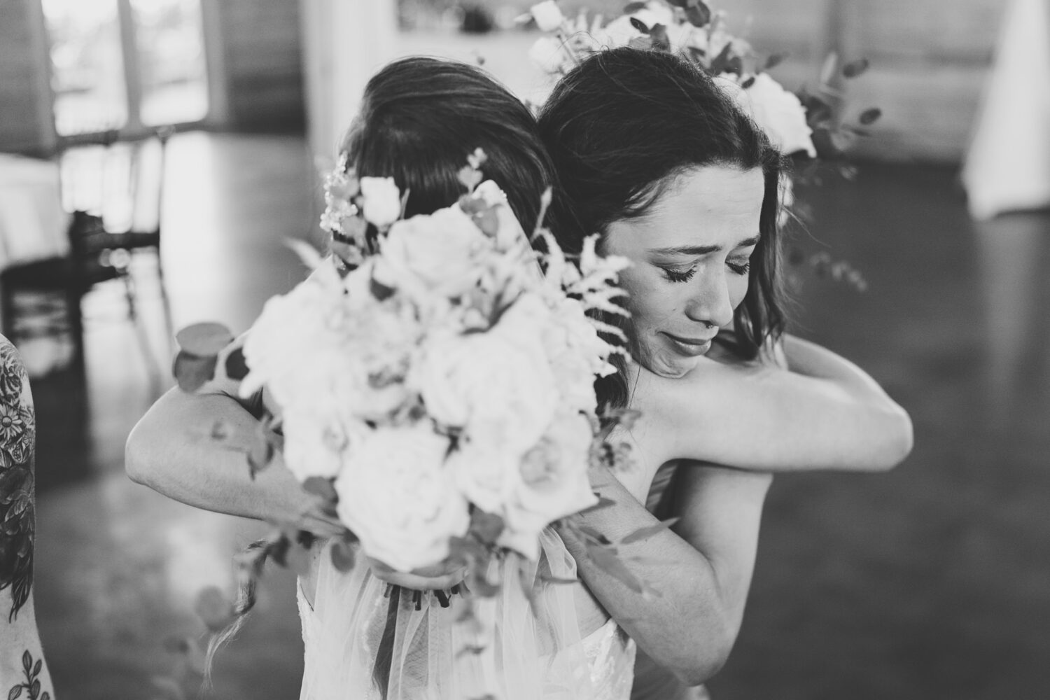 bride and bridesmaid share an emotional hug after the wedding ceremony concludes