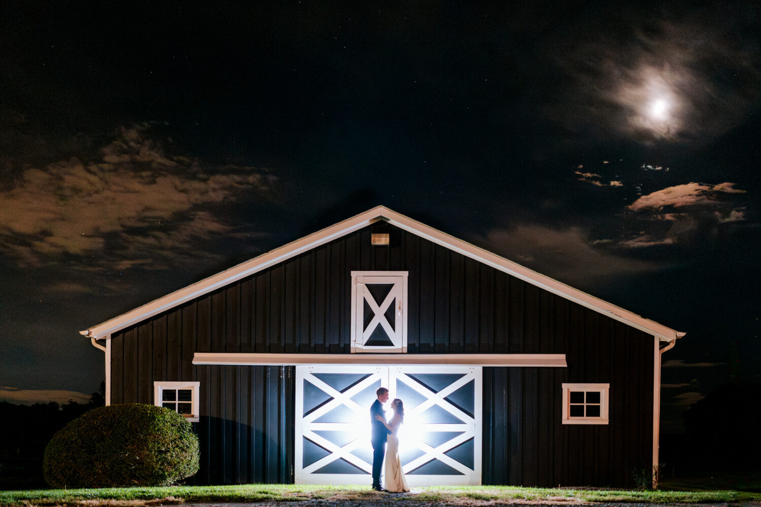 bride and groom taking a creative silhouette portrait together in the night sky