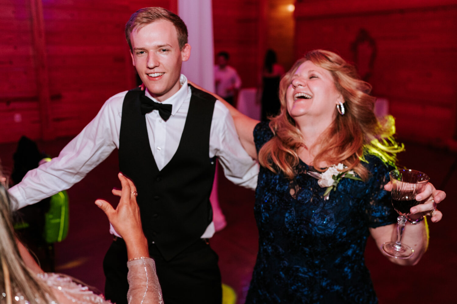 groom having fun on the dance floor with his mother and friends