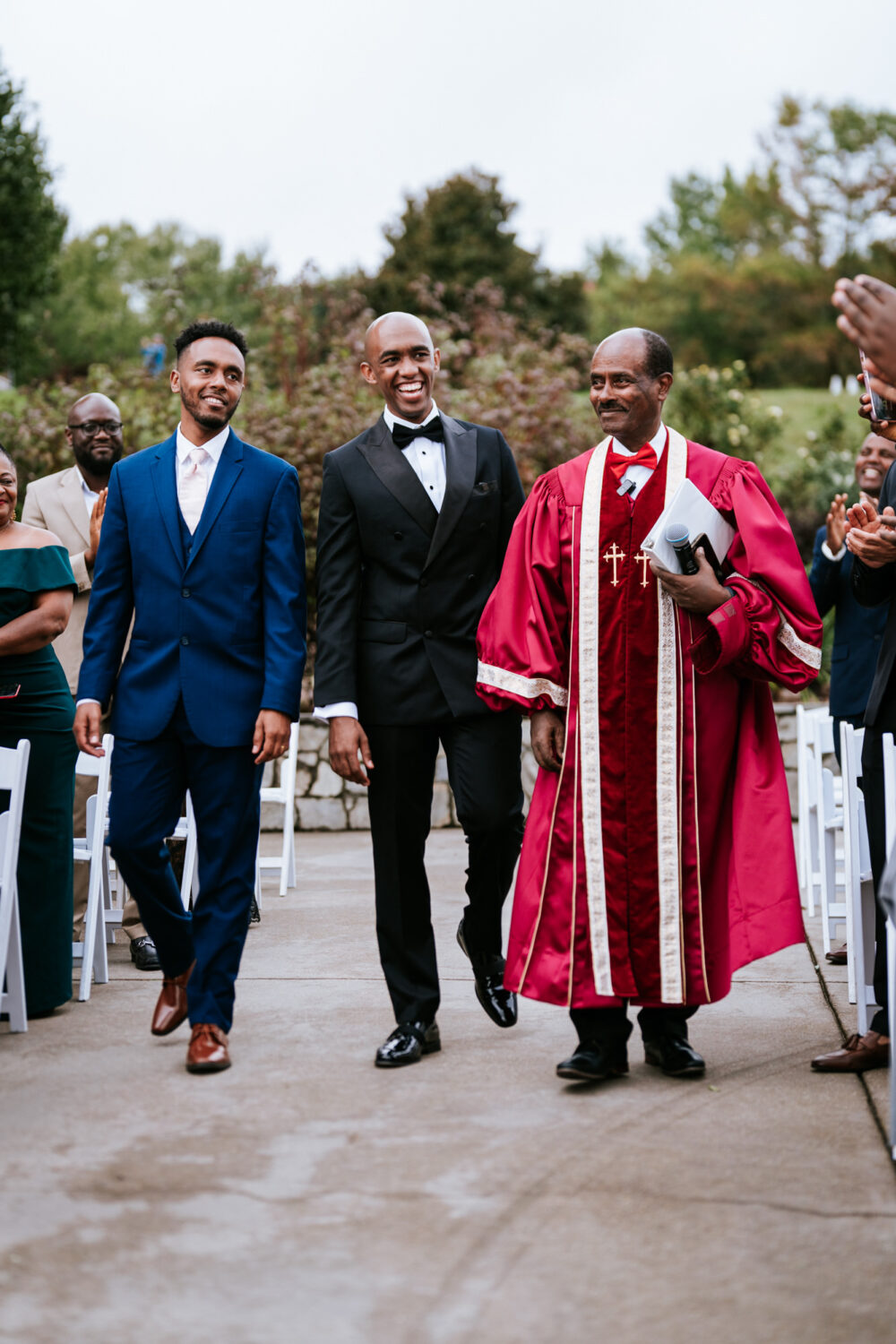 groom walking down the aisle with his officiant and brother