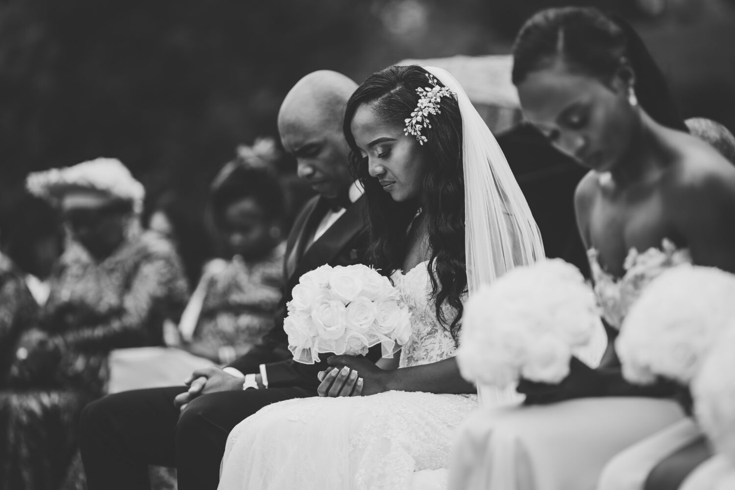 bride and groom bowing their heads in prayer on their wedding day