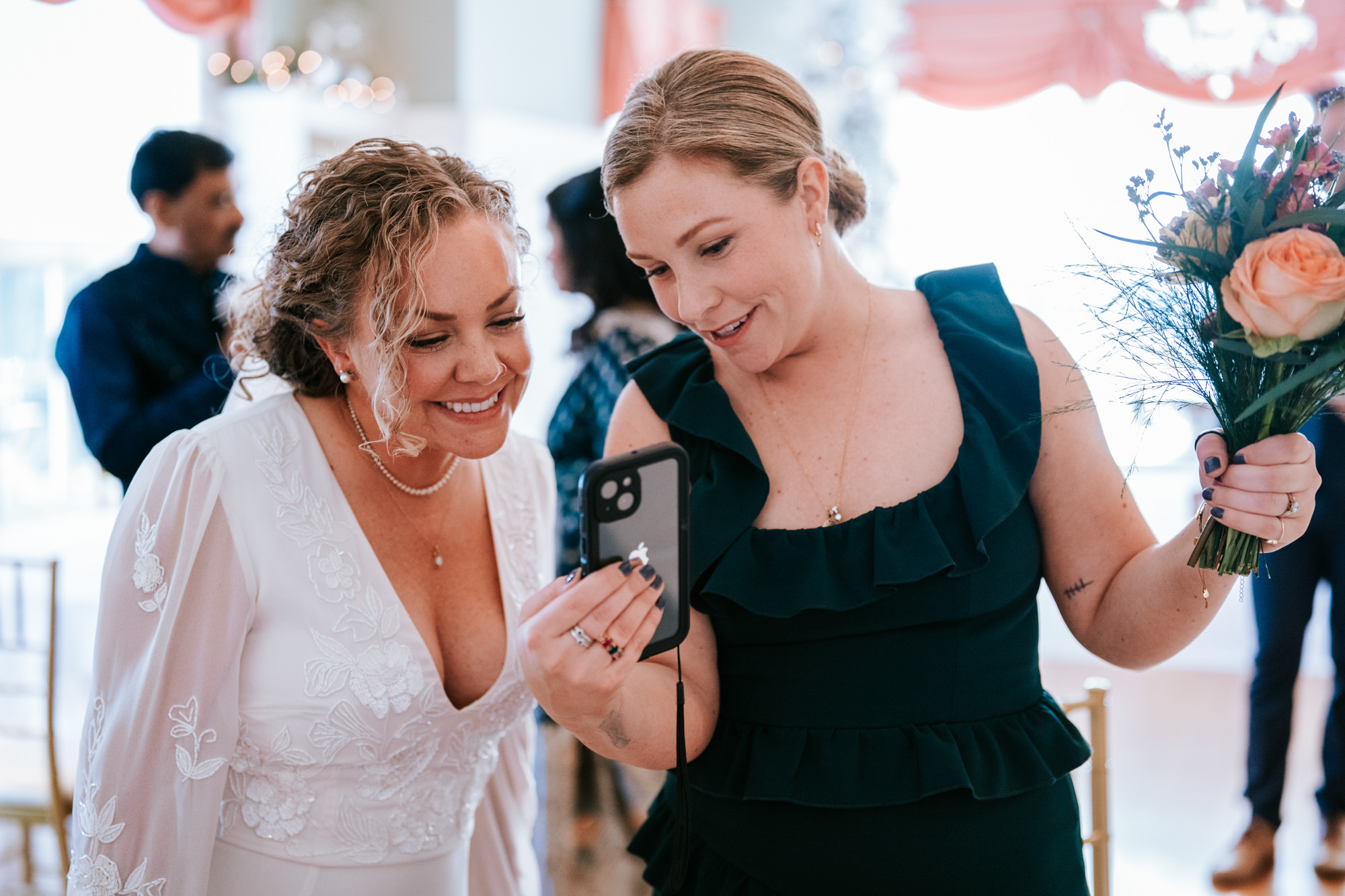 bride and her sister on the phone together talking to wedding guests who couldn't attend the wedding day
