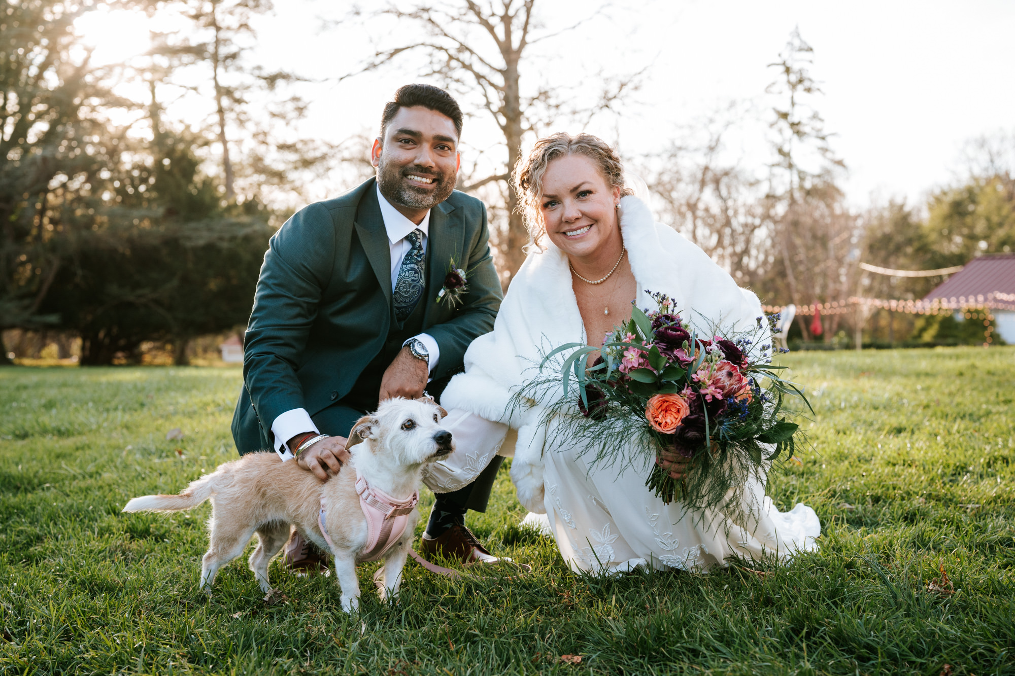 bride and groom taking a portrait with their puppy