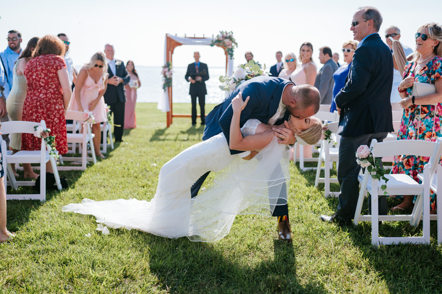 bride and groom kissing in the middle of the aisle as they exit their wedding ceremony at pavilion at weatherly