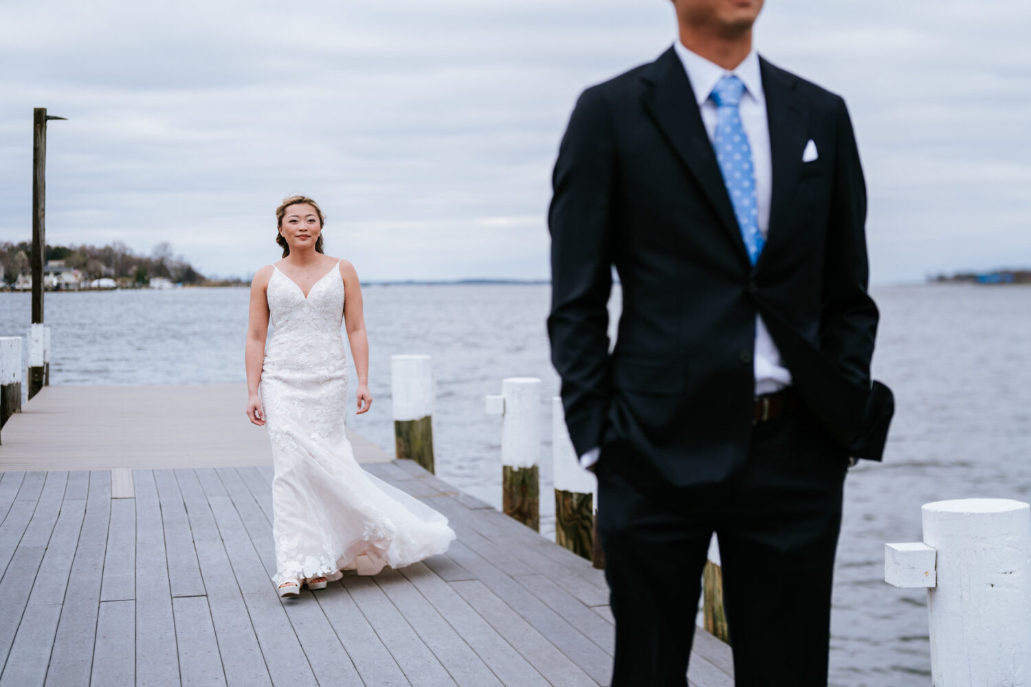bride walking up to groom for their first look on a pier at anchor inn