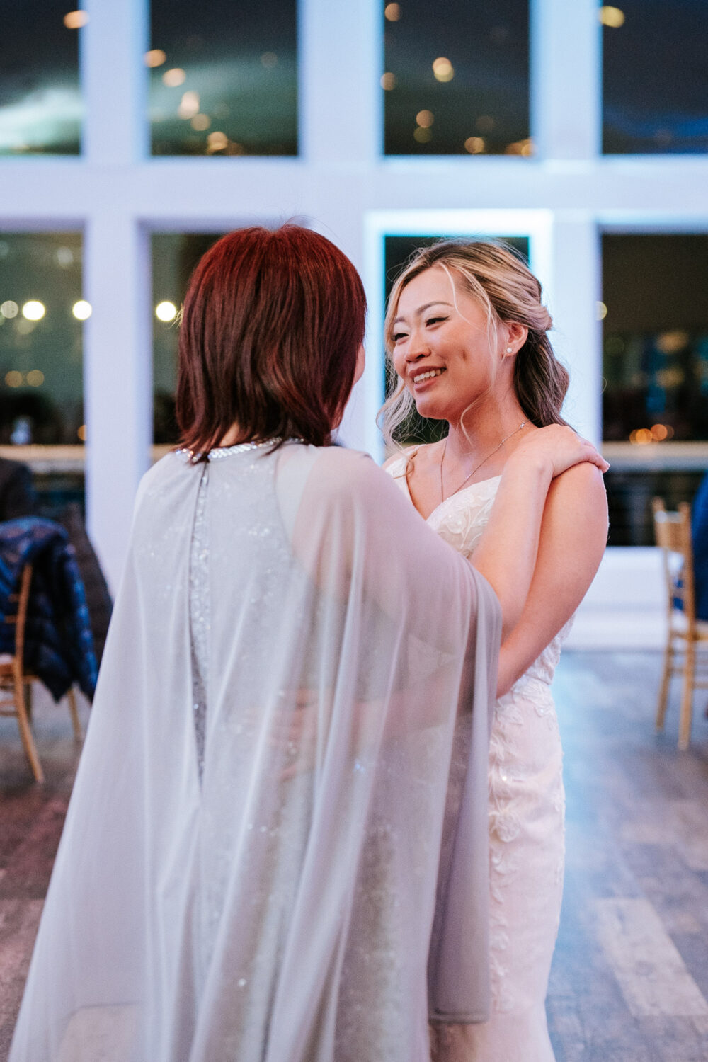 bride smiling at her mother while dancing together