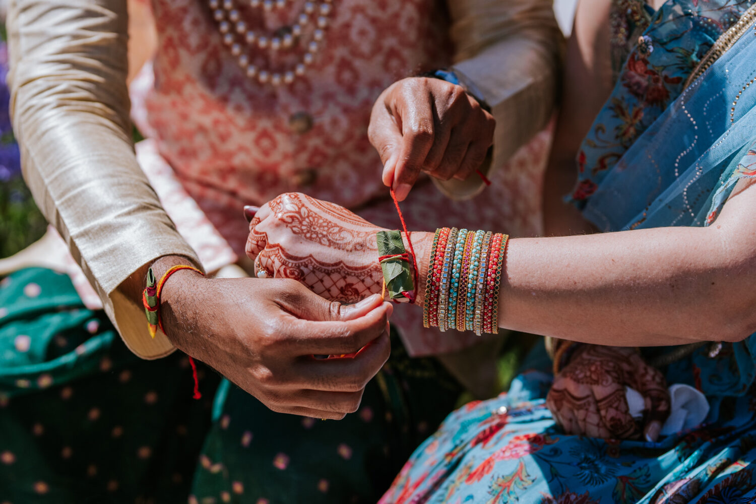 groom tying bracelet on brides wrist