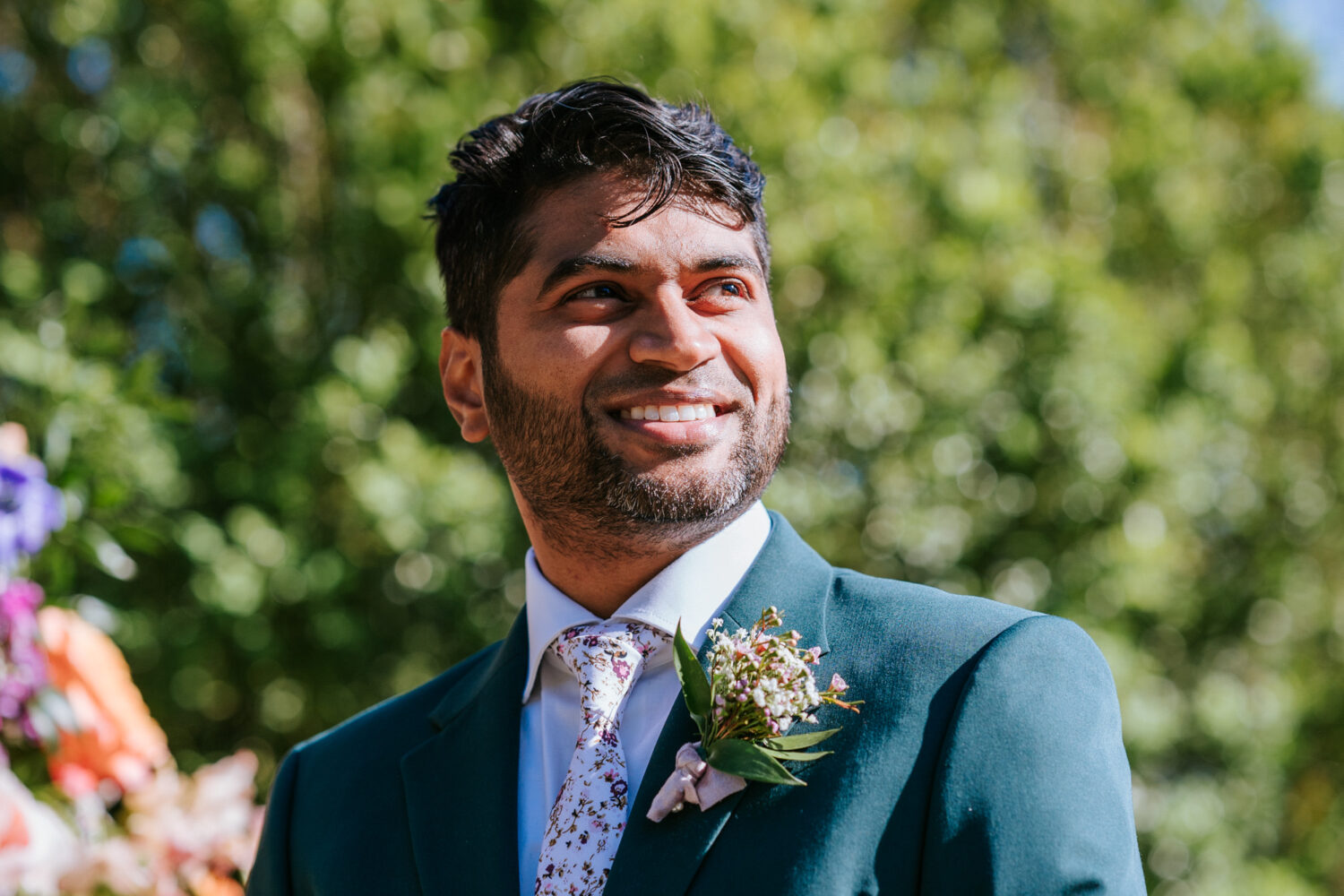 groom smiling while seeing bride walk down the aisle