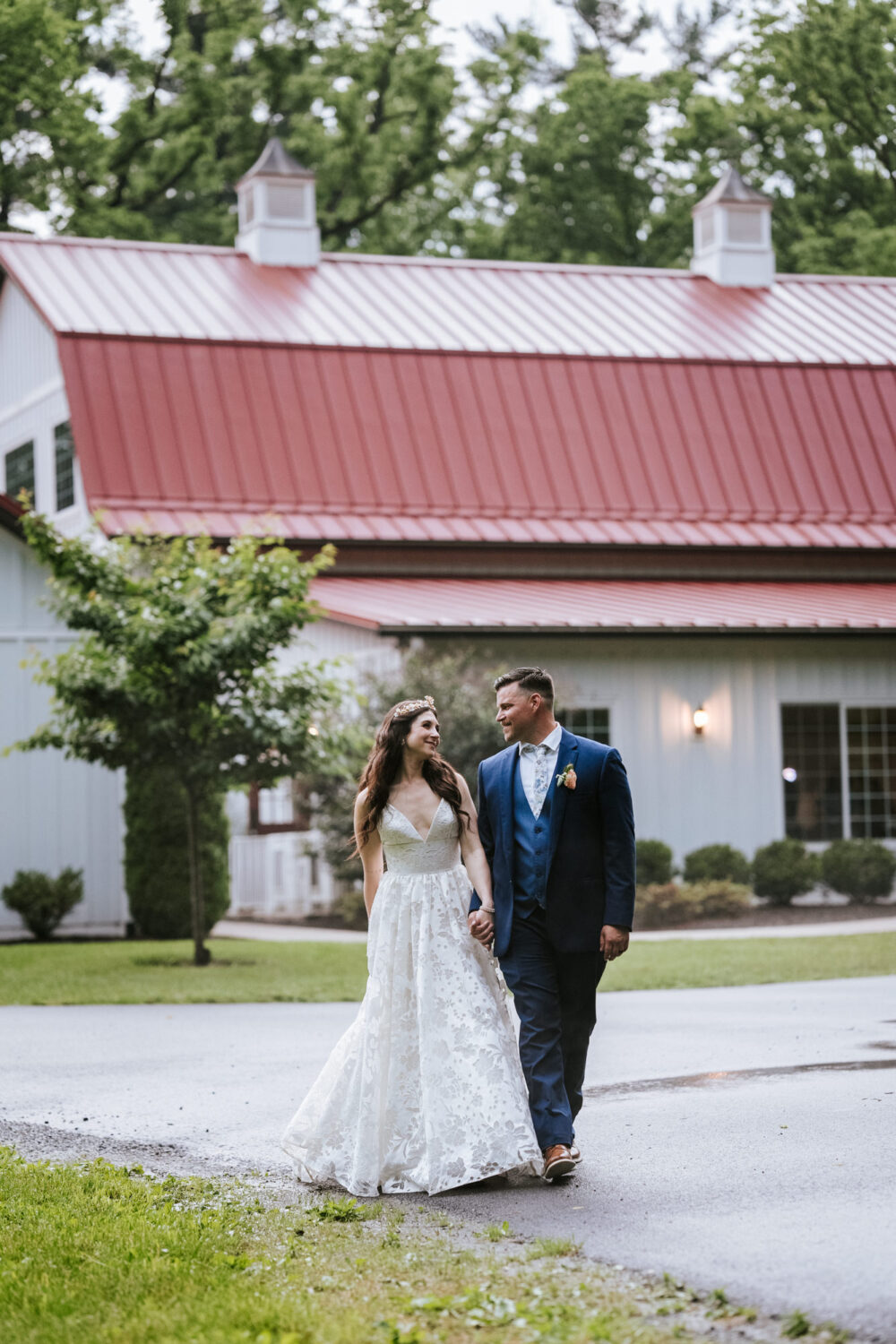 bride and groom walking with the historic rosemont springs wedding venue in the background