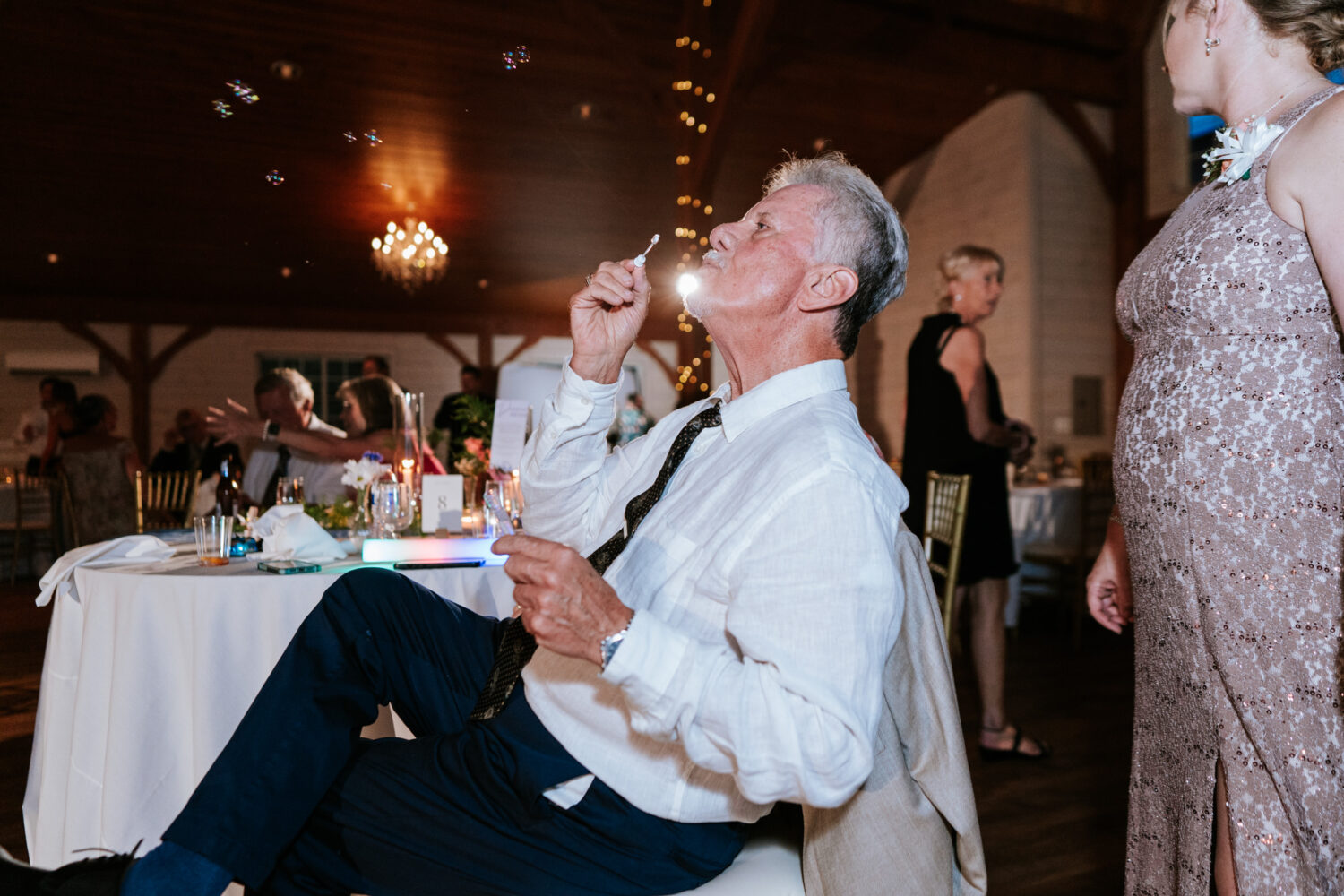 uncle of the bride blowing bubbles during the wedding reception