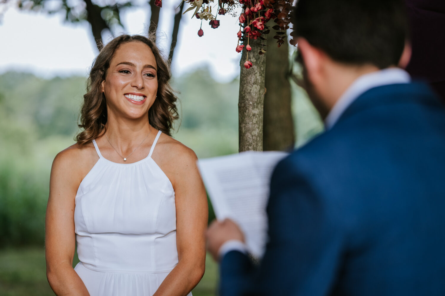 bride smiling while listening to her groom's vows