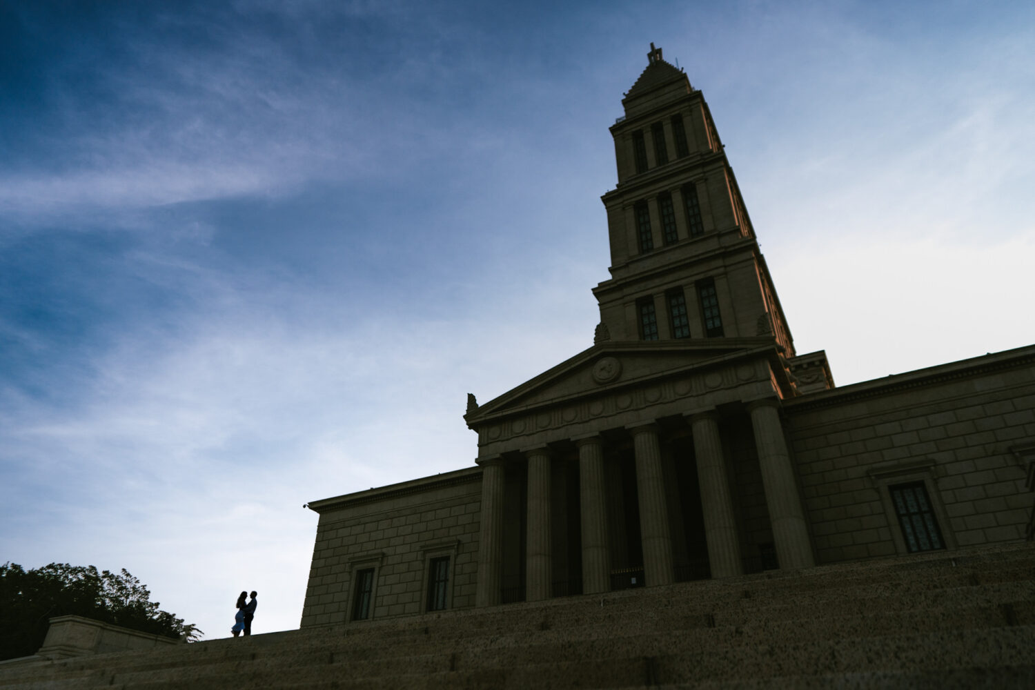 silhouette image of a couple embracing with a historic monument in the background