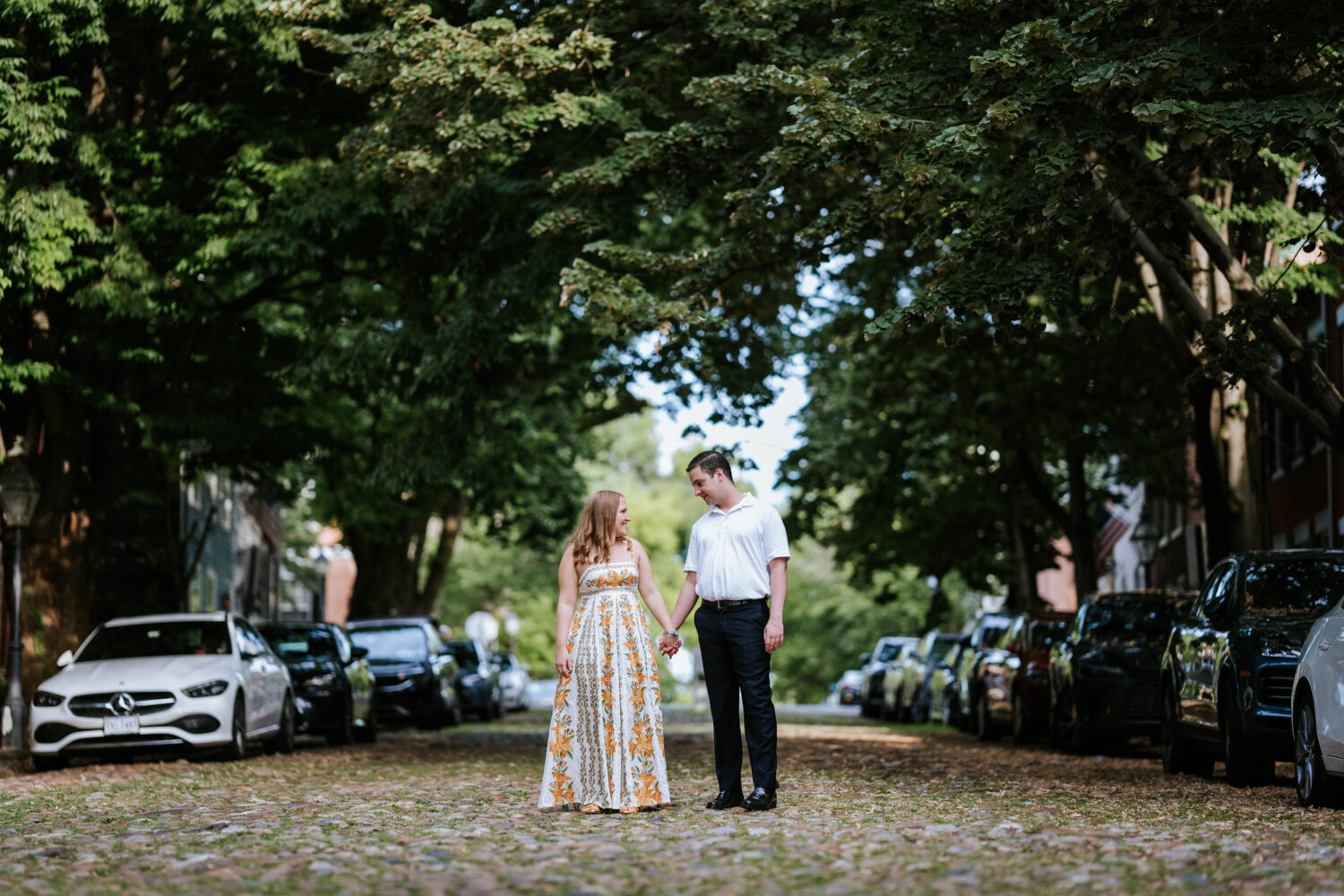 couple hands and smiling while walking down a street together