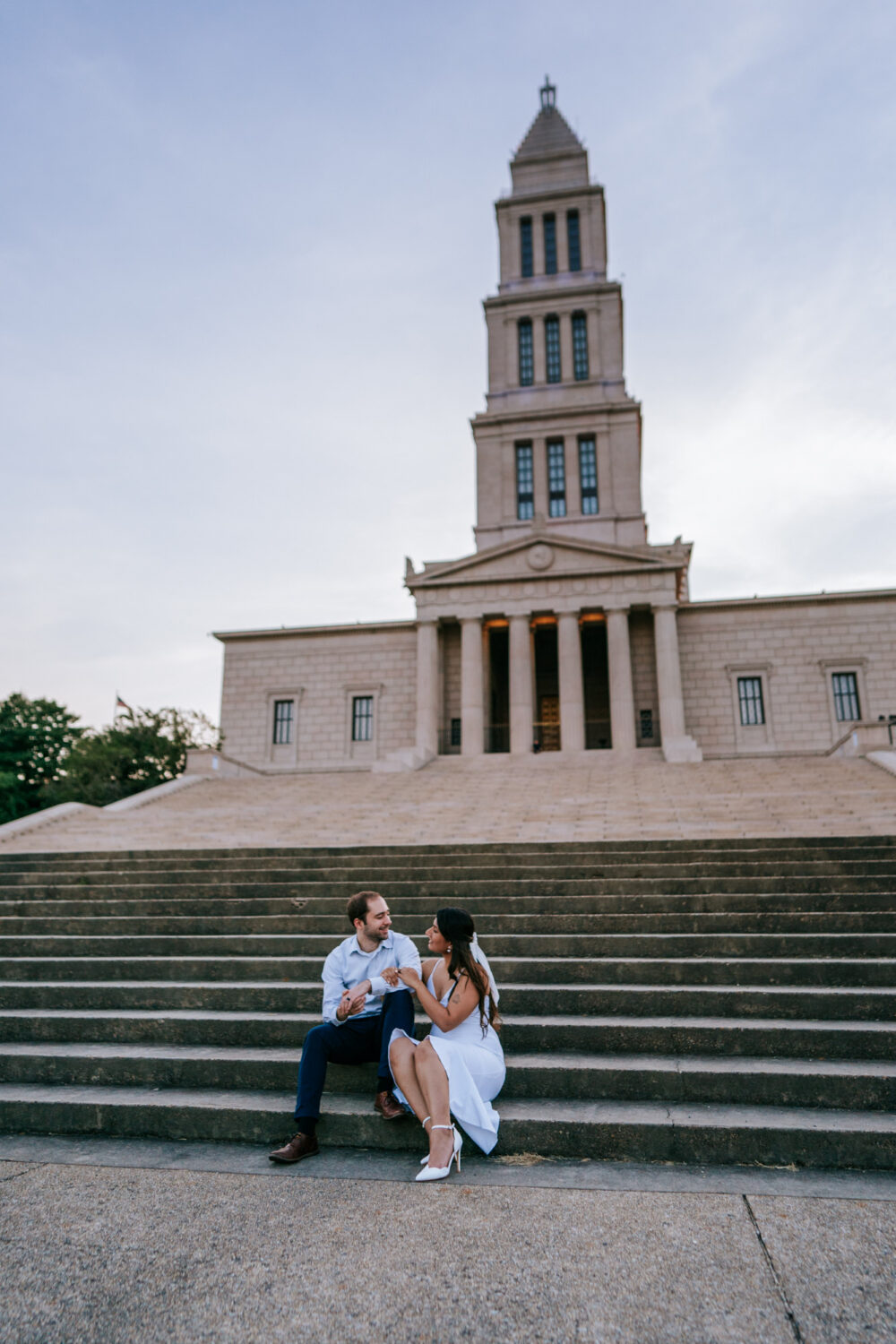 couple looking at each other and smiling while in front of a historic monument