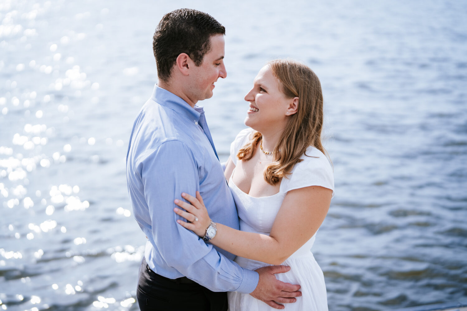 couple looking at each other and smiling with water in the background