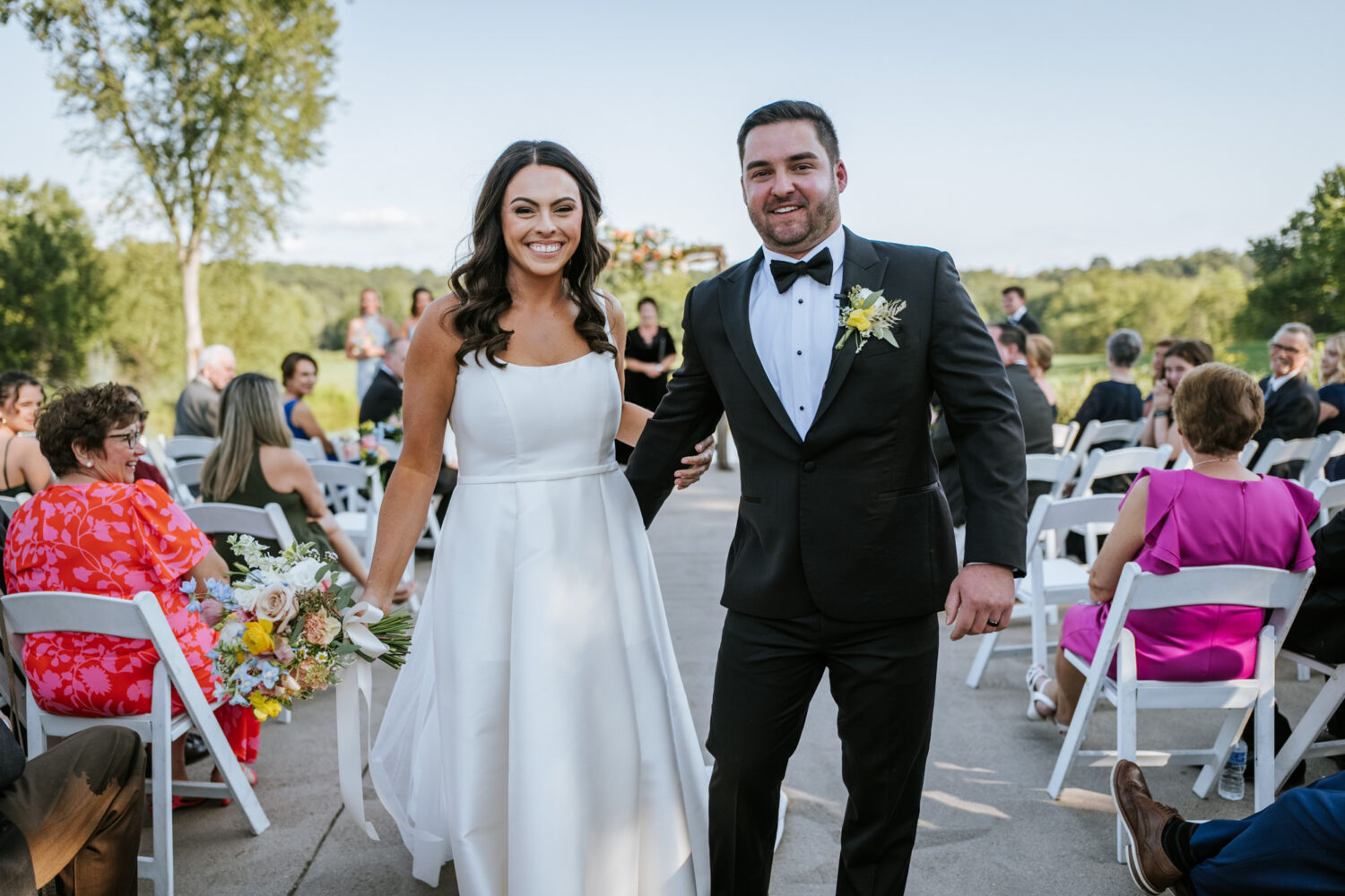 bride and groom smiling as they exit their wedding ceremony together