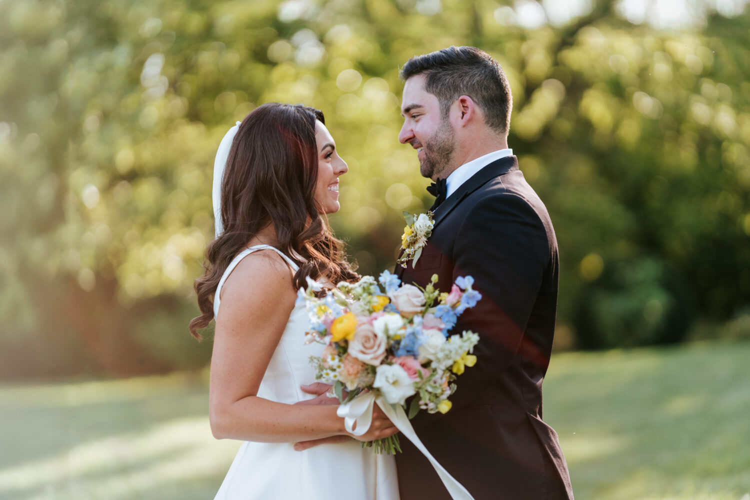 bride and groom looking at each other and smiling during their portrait session